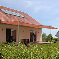Rotes Sonnensegelsystem an einem Haus