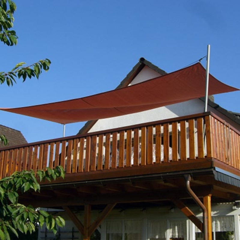 Ein rotes Sonnensegel installiert auf einem Balkon
