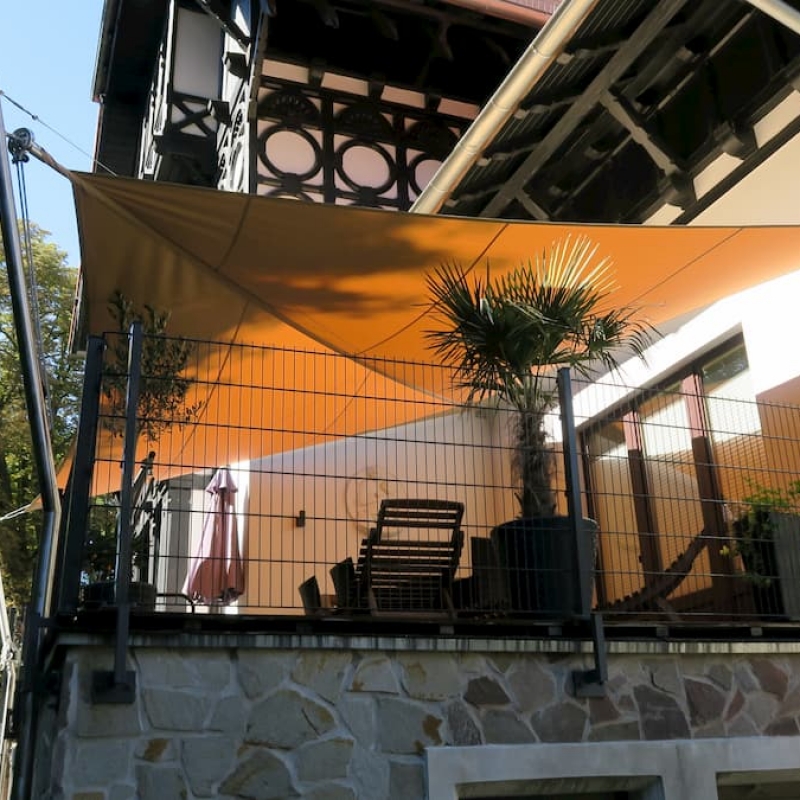 Oranges Sonnensegel beschattet kleinen Balkon